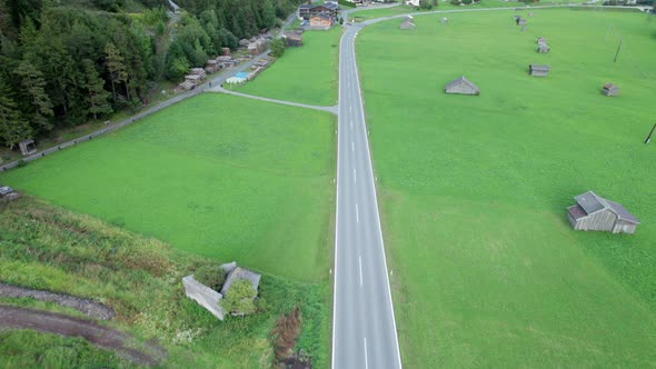 Road in Austria Between Green Fields In an Alpine Village Aerial View