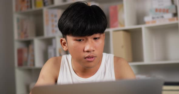 Man working on laptop and sneezing