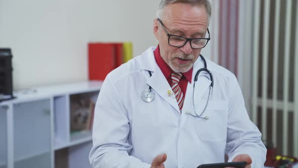 Senior doctor with a phone in medical center.