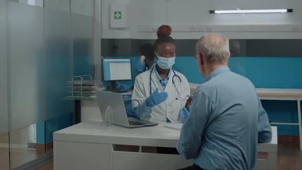 Black Professional Doctor Showing Bottle of Pills