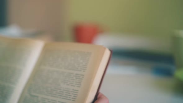 Schoolboy Reads Book at Table Near Eating Friend in Room