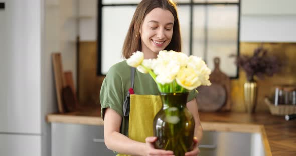 Woman Decorates Home Interior with a Bouquet of Fresh Flowers