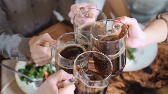Ffriends Clinking Glass with Beer Over Table with Food Slow Motion