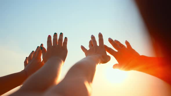 Close Up Many Female Hands Raised Up Against Blue Sky