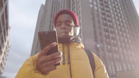 Young Man Using Gadgets in City Center