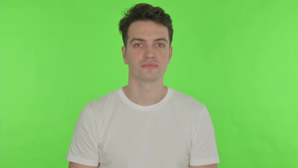 Young Man Shaking Head As Yes Sign on Green Background