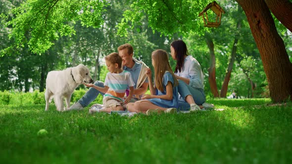 Happy Family Feed White Dog on Weekend Picnic