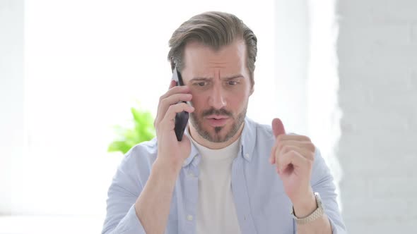 Young Man Talking Angrily on Smartphone