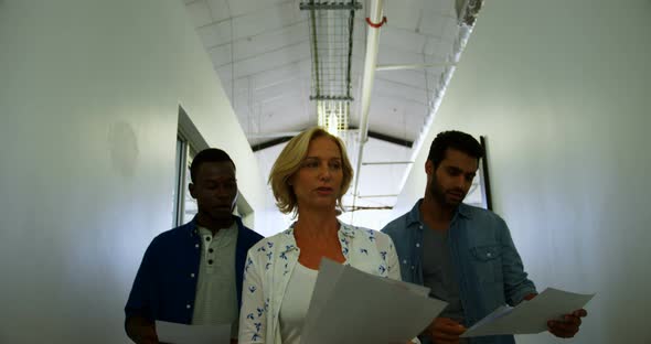 Executives interacting with each other while walking in corridor