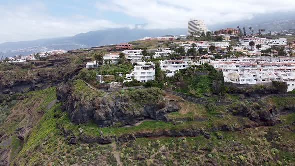 Aerial drone view of residential and hotel complexes next to the coastline in Northern Tenerife, Can