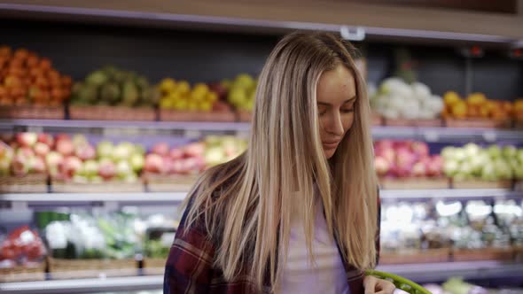 Positive Young Girl Posing While Shopping in the Supermarket
