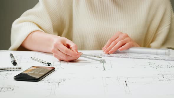 Architect Designer Counting on a Calculator Drawing Plan Blueprint Closeup