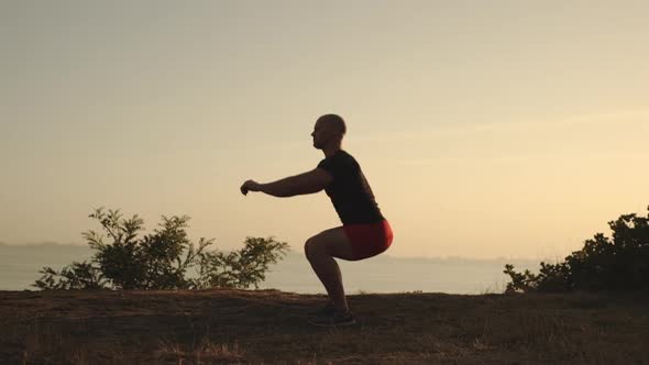 Side View Man with Short Hair Wearing Sport Clothes Doing Situps Working Out Keeping Hands in Front