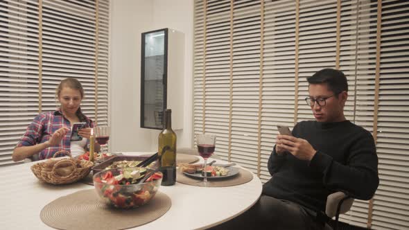 Couple Using Cell Phone On Dinner