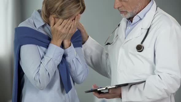 Aged doctor consoling crying female, upsetting news, terminal stage of disease