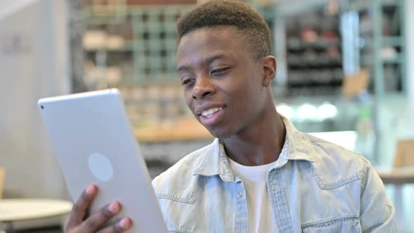 Portrait of Young African Man Doing Video Chat on Tablet