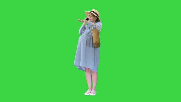 Pregnant Woman Standing and Talking By Phone in Summer on a Green Screen, Chroma Key.