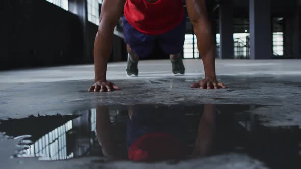 African american man doing push ups in an empty urban building