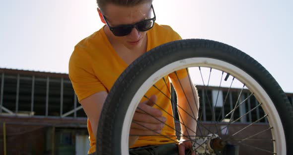 BMX rider repairing wheel