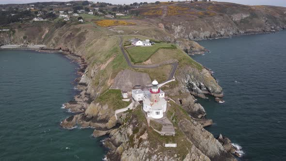 Baily Lighthouse With Bailey Cottage And Town In Background At Howth Head In Howth, Dublin, Ireland.
