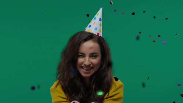 Beautiful Woman Blowing Confetti in the Air Party New Years Eve Celebration Isolated on Green Screen