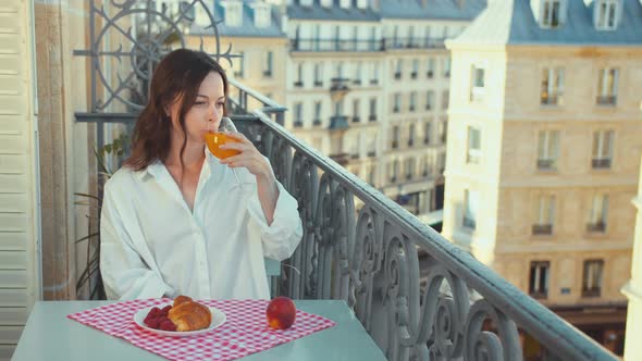 Smiling woman on a balcony in France