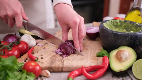 Making Guacamole Sauce  Woman Chopping Red Mars Onion on a Wooden Cutting Board