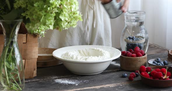 Woman adds sugar, salt, eggs the dough with spatula to make pierogi step-by-step recipe