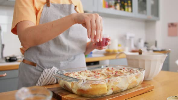 Woman Decorating Roll Buns with Dried Raspberries