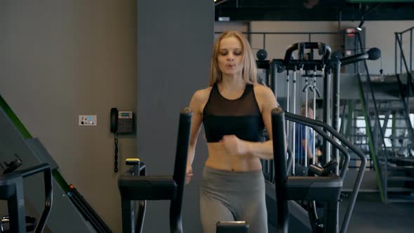 Woman Running on Treadmill Machine in Gym