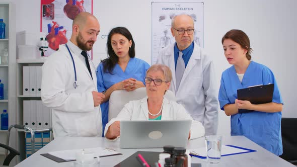 Doctors in Lab Coats Working in Hospital Office Discussing Symptoms of Disease