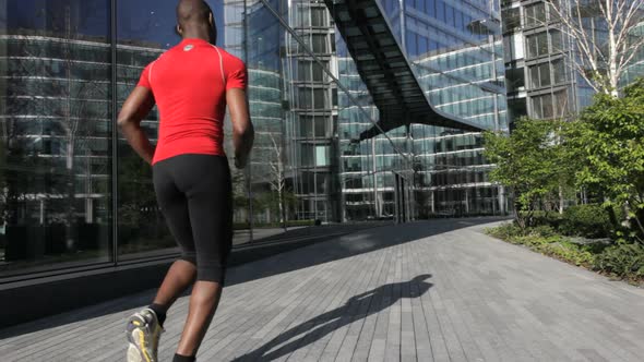 Runner, passing business offices, London, UK