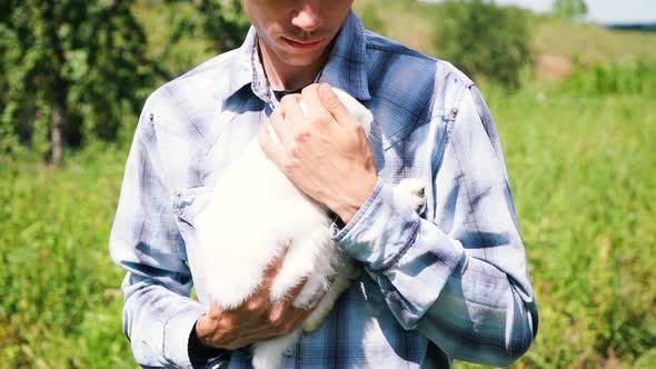 Young Boy of Caucasian Ethnicity Blue Checkered Shirt Holds a Cute Fluffy Domestic White Rabbit in