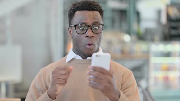 Creative African Man Celebrating on Smartphone