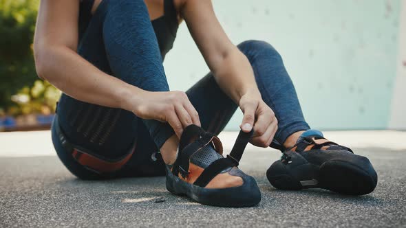 Close Up of Woman Putting on Climbing Shoes Outdoors