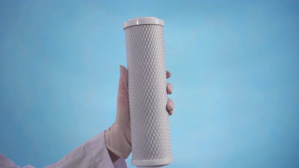 Woman's Hand in a Robe and Gloves Holds a Clean Water Filter Cartridge