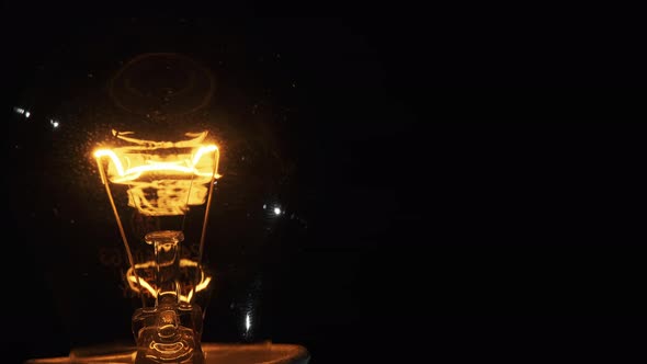 Tungsten Filament in a Glass Lamp Closeup in Slow Motion on Black Background