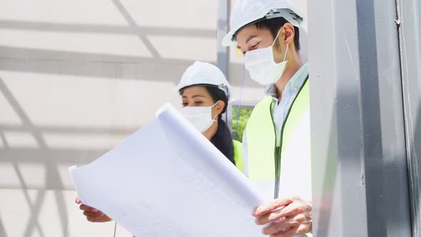 Asian workers people wearing protective face mask onsite of architecture due to COVID 19 pandemic.