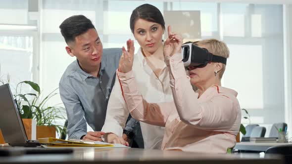 Mature Businesswoman Using 3d Virtual Reality Goggles at Work