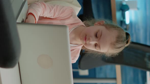 Vertical Video Portrait of Young Girl Working on Laptop for School Lessons
