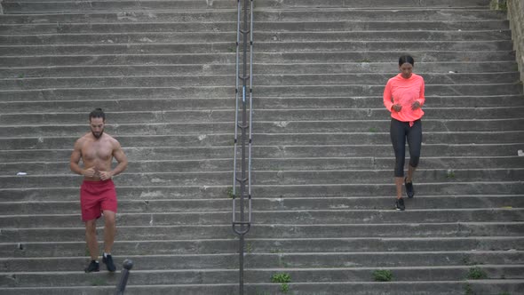 A couple running on stairs in a city as a workout