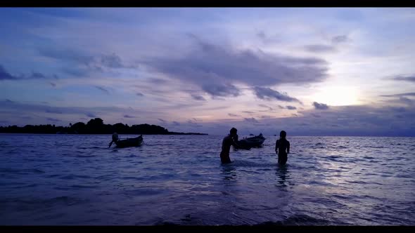 Boy and girl posing on luxury seashore beach voyage by blue sea with white sandy background of the M