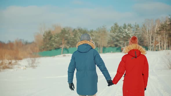 Couple Walking And Enjoying Winter. Freezing Day On Holiday Vacation Trip. Snowy Park.