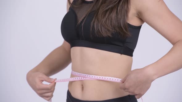 Young Multi-ethnic Woman Measuring Waist Ready for Gym