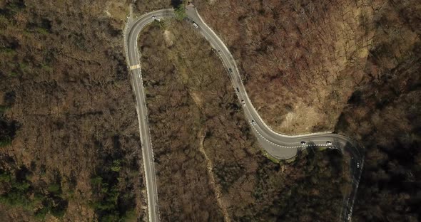 Aerial Autumn Road From Above View of Cars on a Zig Zag Road. Season Forest Road Landscape. Mountain