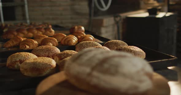 Animation of close up of fresh baked breads and rolls at bakery