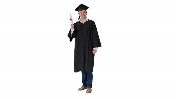 Happy Male Student in Graduation Robe Posing and Waiving with His Diploma on White Background