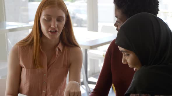 Young adult female friends hanging out in a cafe