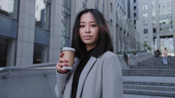 Coming Out of Focus From a Portrait of a Young Asian Enterpreneur on the City Street