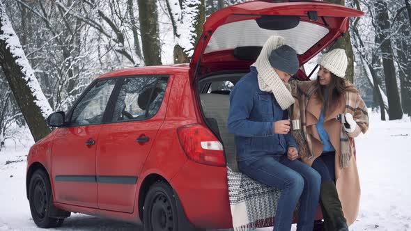 Tea party in car trunk - loving couple sits in car trunk in Valentine's day